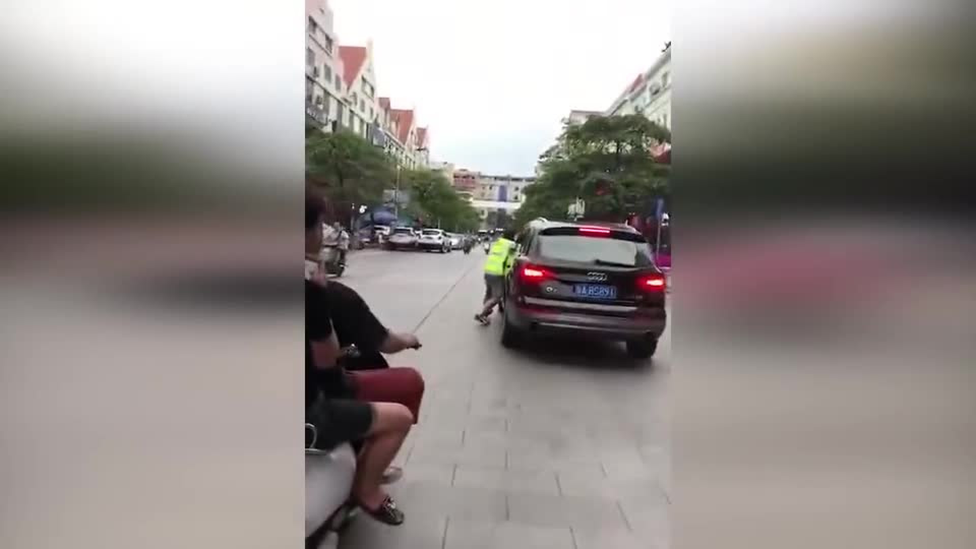 气愤! 奥迪车主拒付停车费 当街拖行收费员